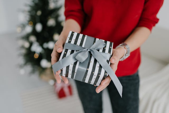 Influencer holding a wrapped gift box from a company that uses the concept of monetization through sponsored content and brand partnerships.